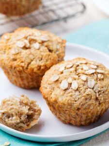 Apfel-Vanille-Muffins ohne Zucker auf einem Teller, ein Muffin aufgebrochen
